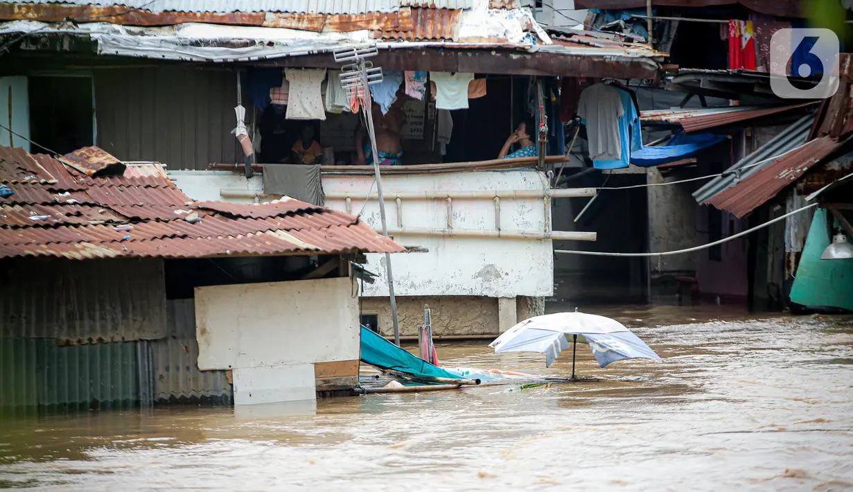 Aktivitas warga permukiman bantaran Sungai Ciliwung saat terendam banjir, Jakarta, Senin (10/10/2022). Hingga pukul 09.00 WIB hari ini, Badan Penanggulangan Bencana Daerah (BPBD) DKI Jakarta mencatat sebanyak 68 RT di Jakarta terendam banjir akibat luapan Sungai Ciliwung. (Liputan6.com/Faizal Fanani)