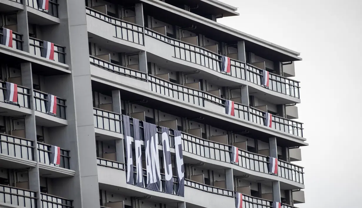 Bendera dan spanduk tim dari Prancis terlihat di sebuah gedung di kawasan wisma atlet Olimpiade dan Paralimpiade Tokyo 2020, di Tokyo pada Rabu (14/7/2021). Olimpiade Tokyo 2020 bakal berlangsung di Jepang selama 17 hari mulai 23 Juli hingga 8 Agustus 2021.  (Behrouz MEHRI / AFP)