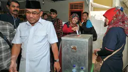 Calon Walikota Depok, Mohammad Idris dan istri usai memasukkan surat suara kedalam kotak di TPS 077 di Perum Pondok Duta, Depok, (9/12). Mohammad Idris diusung oleh Partai Keadilan Sejahtera (PKS) dan Partai Gerindra. (Liputan6.com/Yoppy Renato)
