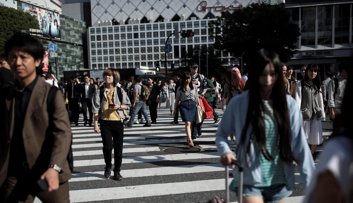 Pejalan kaki berjalan melintasi persimpangan Shibuya di Tokyo, Jepang (23/5/2019). Kota Shibuya memiliki Luas wilayah adalah 15.11 km².(AFP Photo/Behrouz Mehri)