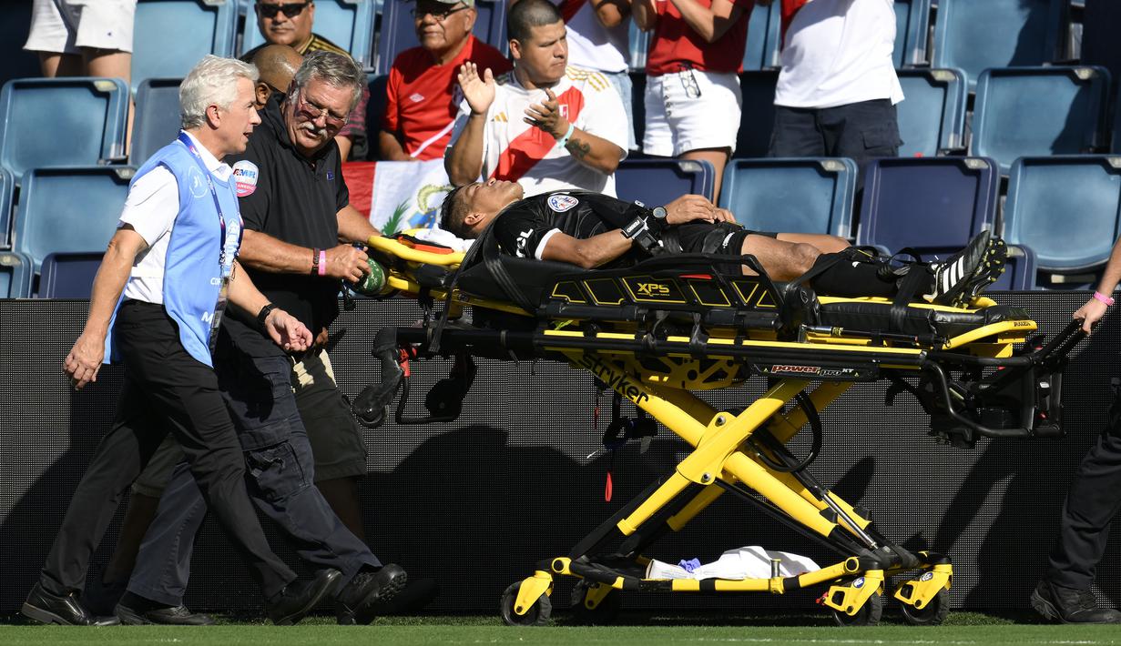 Asisten wasit Humberto Panjoj ditandu keluar lapangan setelah mengalami pingsan pada laga Grup A Copa America 2024 antara Peru melawan Kanada di Children's Mercy Park, Kansas City, Kansas, Selasa (25/06/2024) waktu setempat. (AP Photo/Reed Hoffmann)