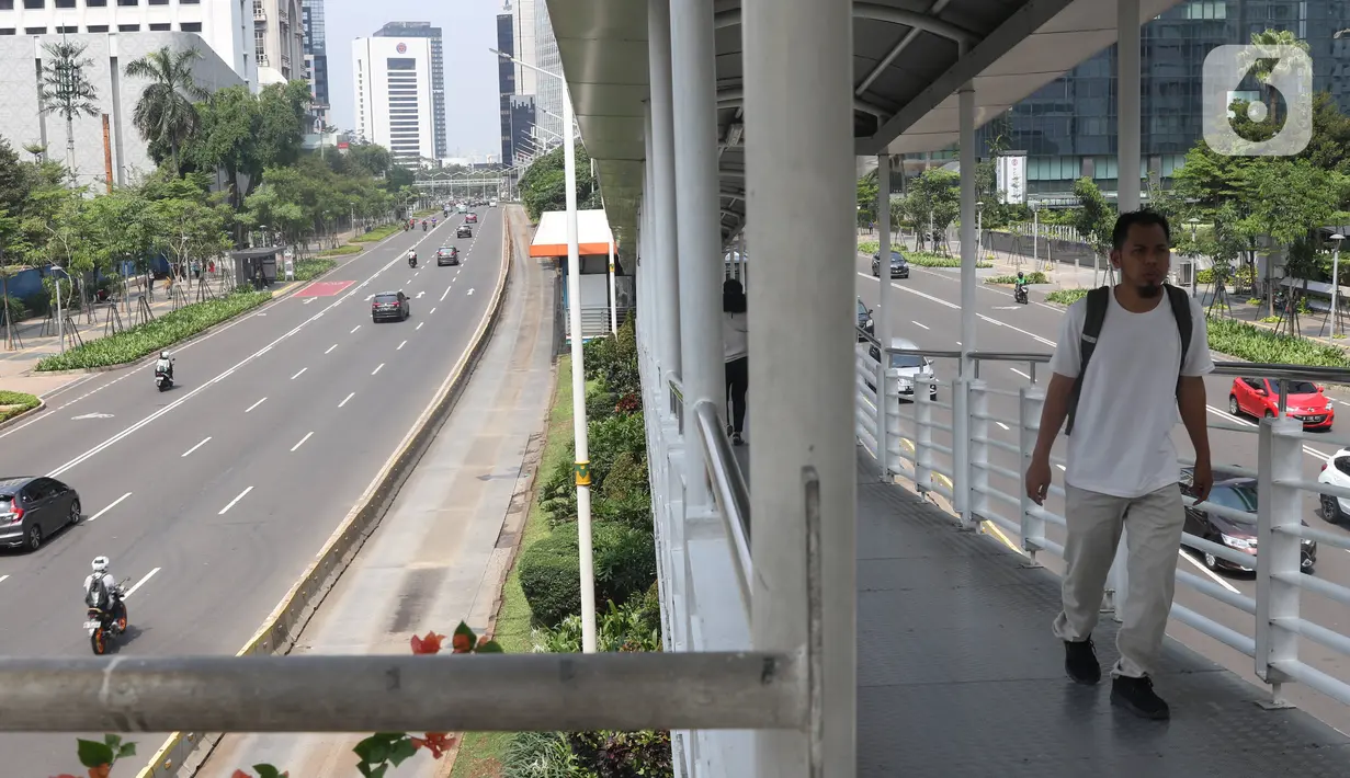Pejalan kaki melintasi jembatan penyeberangan orang (JPO) di Ibu Kota Jakarta, Selasa (24/12/2019). Libur Natal dan Tahun Baru membuat kondisi lalu lintas di Jakarta lengang. (Liputan6.com/Angga Yuniar)