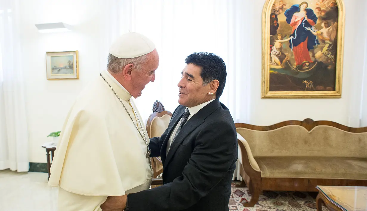 Paus Fransiskus (kiri) bersalaman dengan mantan pesepak bola Argentina, Diego Armando Maradona sebelum pertemuan dengan anggota organisasi Scholas Occurentes di Vatikan pada tanggal 4 September 2014. (AFP/Filippo Monteforte)