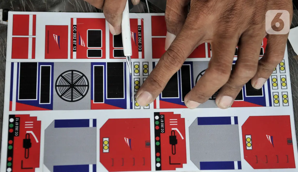 Iskandar memotong stiker miniatur kereta api, Jakarta, Kamis (21/11/2019). Sedangkan miniatur skala 1:87 (standar internasional) jenis manual Rp400.000 per rangkaian (1 lokomotif-3 gerbong), sementara jenis baterai Rp800.000 per set (1 lokomotif, 3 gerbong, dan rel). (merdeka.com/Iqbal S. Nugroho)