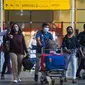 Penumpang yang tiba meninggalkan terminal di Bandara Internasional Chhatrapati Shivaji Maharaj di Mumbai, India pada 1 Desember 2021. (PUNIT PARANJPE / AFP)