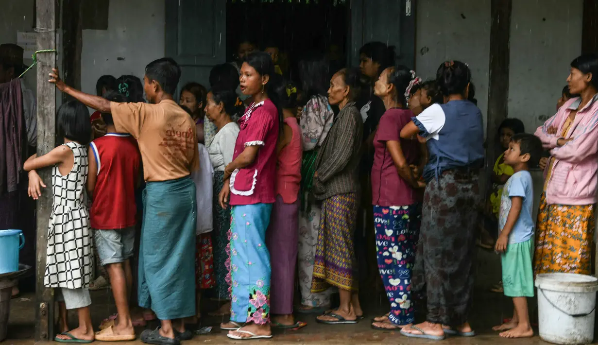 Warga yang mengungsi sementara akibat banjir mengantre makanan di sebuah sekolah yang digunakan sebagai tempat pengungsian di Taungoo, wilayah Bago, Myanmar, pada tanggal 12 September 2024. (Sai Aung MAIN/AFP)