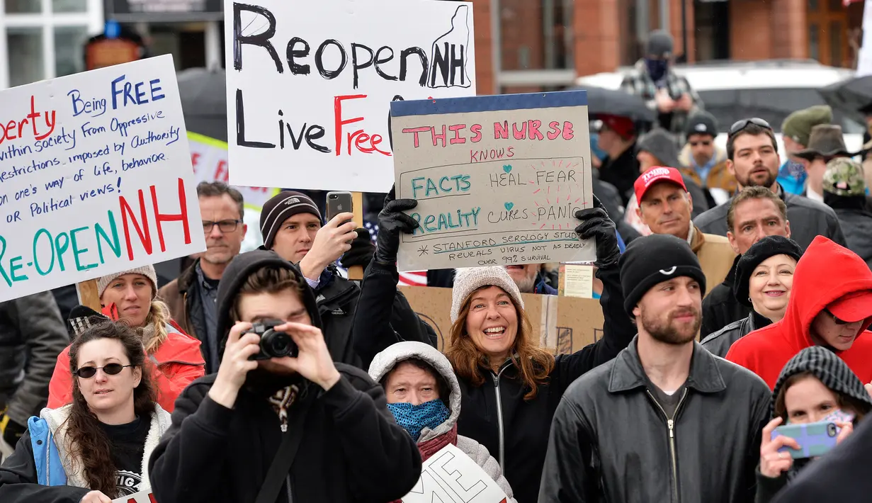 Ratusan penduduk New Hampshire melakukan aksi unjuk rasa menyerukan pencabutan lockdown di State House di Concord, Sabtu (18/4/2020).  Mereka meminta kebijakan yang ditujukan mencegah penyebaran COVID-19 segera dicabut, karena berdampak terhadap perekonomian. (Joseph Prezioso / AFP)