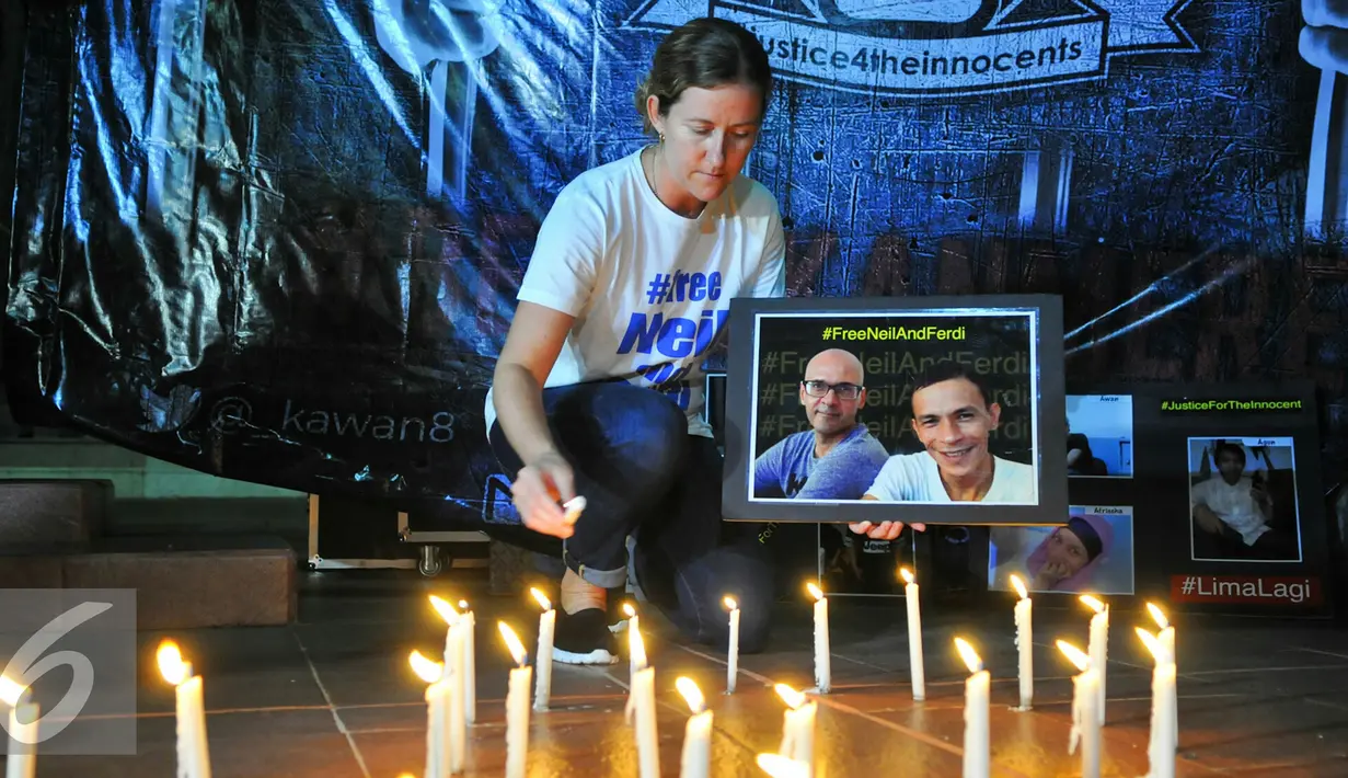 Tracy Bantleman, istri Neil Bantleman guru Jakarta International School (JIS) asal Kanada menyalakan lilin dalam malam Solidaritas kasus JIS di Tugu Proklamasi, Jakarta, Jumat (20/5/2016). (Liputan6.com/Yoppy Renato)