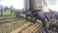 Petugas evakuasi gabungan tengah mengangkat kereta yang tabrakan di jalur petak stasiun Cicalengka-Haurpugur Kabupaten Bandung, Jawa Barat. (Liputan6.com/Humas PT KAI Daop 2 Bandung)