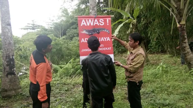 Pemasangan pamflet untuk memperingatkan agar warga tak berakitivitas di aliran sungai Luk Ulo lantaran ada buaya. (Foto: Liputan6.com/Muhamad Ridlo/BKSDA)