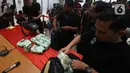 Petugas menata barang bukti saat rilis pengungkapan peredaran narkotika jenis sabu di Bareskrim Polri, Jakarta, Rabu (12/2/2020). Dirtidpid Narkoba Polri mengungkap sindikat narkotika jaringan Malaysia-Indonesia dengan barang bukti sabu 59 kg dan 20 butir pil ekstasi. (Liputan6.com/Angga Yuniar)