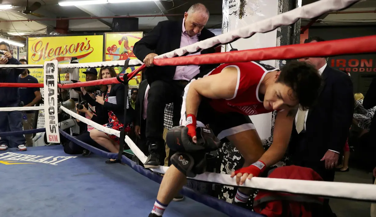 PM Kanada, Justin Trudeau masuk ke arena ring tinju saat akan bermain tinju dengan petinju profesional Yuri Foreman di Gleason Boxing Gym di Brooklyn borough New York, AS (21/4). (REUTERS/Carlo Allegri)