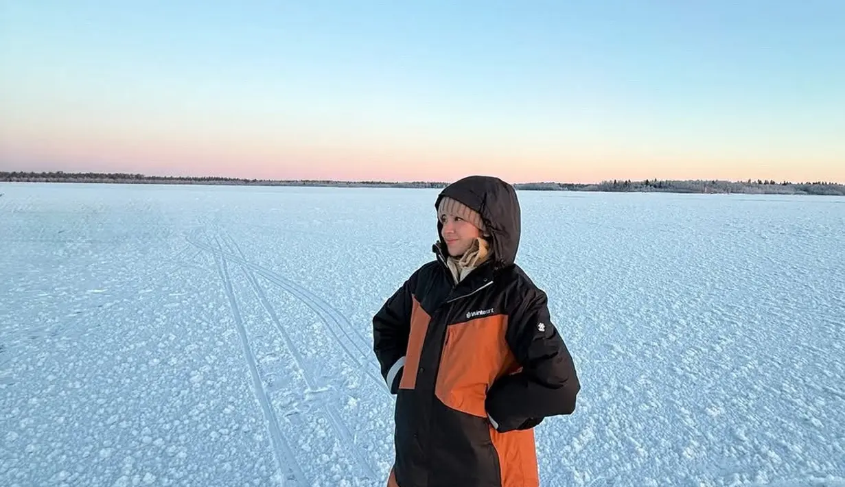 Lyodra pun memerlihatkan hamparan salju putih yang indah. Ia pun masih dengan jaket dan celana tebal warna hitam dan orange serta mengenakan beanie coklat. [@lyodraofficial]