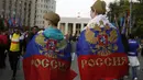 Fans Rusia membawa bendera saat menuju Luzhniki stadium di Moskow, Rusia, (14/6/2018). Rusia akan melawan Arab Saudi pada laga pembuka.. (AP/Rebecca Blackwell)