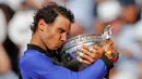 Petenis Spanyol, Rafael Nadal mencium trofinya setelah mengalahkan Stan Wawrinka pada final Prancis Terbuka di Roland Garros, Minggu (11/6). Nadal unggul dengan skor 6-2, 6-3, 6-1 untuk meraih gelar kesepuluh atau La Decima. (AP Photo/Christophe Ena)