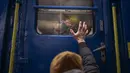 Stanislav (40) mengucapkan selamat tinggal kepada putranya David (2) dan istrinya Anna (35) di kereta api menuju Lviv di stasiun Kiev, 3 Maret 2022. Stanislav tinggal untuk membela negara sementara keluarganya meninggalkan Ukraina mencari perlindungan di negara tetangga. (AP Photo/Emilio Morenatti)