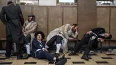 Pria Yahudi ultraortodoks beristirahat setelah mabuk saat perayaan Hari Raya Purim di lingkungan ultraortodoks Mea Shearim, Yerusalem, 8 Maret 2023. Hari Raya Purim merupakan perayaan keselamatan orang Yahudi dari genosida di Persia kuno, seperti yang diceritakan dalam Gulungan Ester. (AP Photo/Ohad Zwigenberg)