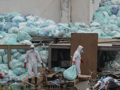 Petugas medis mengenakan alat pelindung diri saat membuang limbah biologis berbahaya di luar Rumah Sakit del Instituto Mexicano del Seguro Social, Veracruz, Meksiko, Rabu (12/8/2020). Pembuangan limbah medis yang tidak tepat menjadi masalah di tengah pandemi COVID-19. (AP Photo/Felix Marquez)