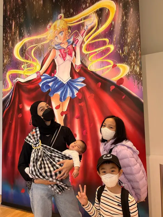 Sambil menggendong sang bayi, Dian Ayu Lestari dan kedua anaknya berpose berlatar Sailor Moon di dalam museum. (Foto: Instagram/@dianayulestari)