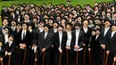 Sejumlah penggemar menggelar pertemuan dengan mengenakan kostum Charlie Chaplin di Corsier sur Vevey, Minggu (16/4). Mereka menirukan gaya Charlie Chaplin lengkap dengan topi, kumis kotak, dan tongkat kayu.  (Laurent Gillieron/Keystone via AP)