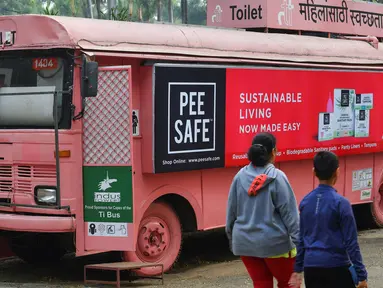 Foto pada 9 Februari 2020 menunjukkan orang-orang berjalan melewati toilet keliling di sebuah bus di taman umum di Pune, India. Proyek Ti Toilet, sebuah bus yang diubah menjadi toilet dan diluncurkan pada tahun 2016, adalah gagasan Ulka Sadalkar dan Rajeev Kheer. (Indranil MUKHERJEE/AFP)