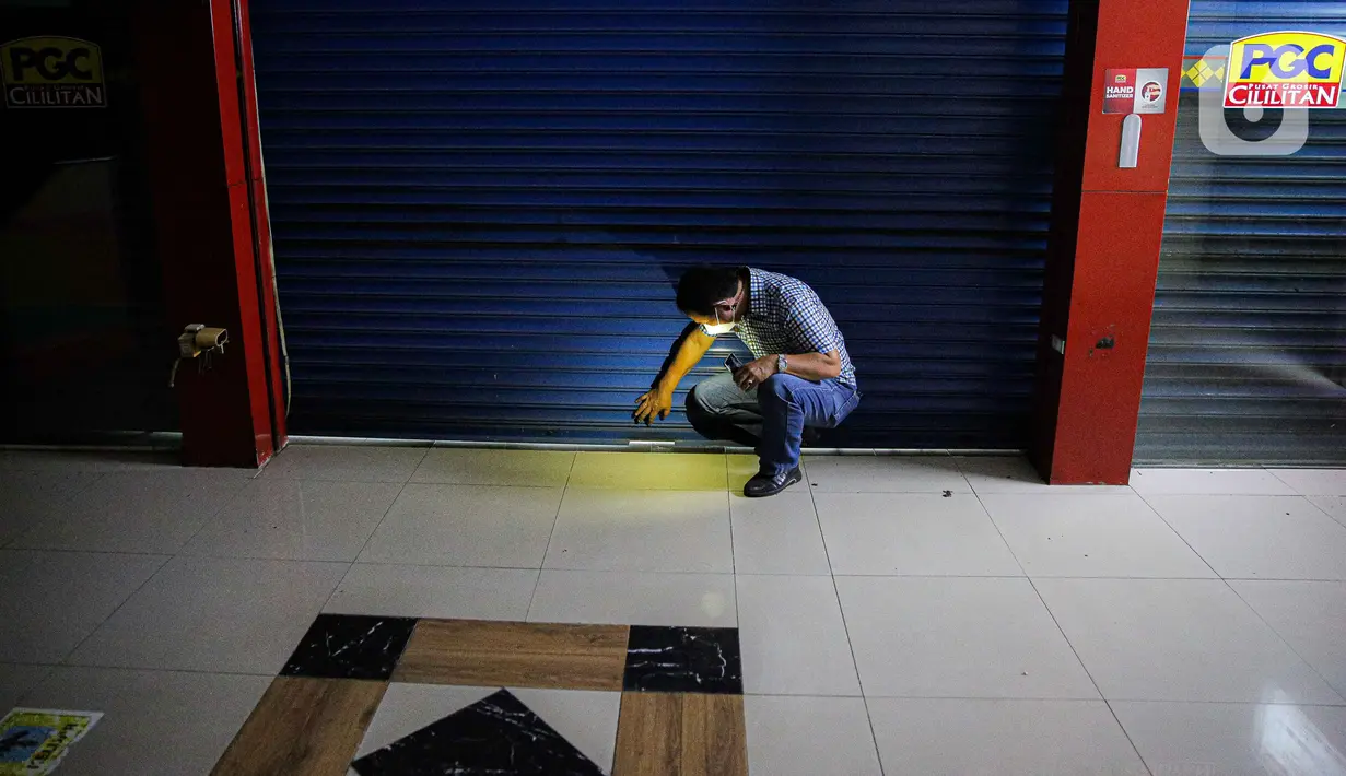 Petugas mengecek kondisi tenant tutup di Mall PGC Cililitan, Jakarta, Selasa (27/7/2021). Menurut keterangan pedagang, pemerintah harus memberikan perhatian kepada para pedagang dan pelaku UMKM di mal dan pusat perbelanjaan seiring diperpanjangnya PPKM Level 4. (Liputan6.com/Faizal Fanani)