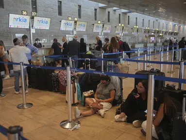 Para pelancong mengantre untuk pelaporan masuk penerbangan menyusul pengumuman gencatan senjata antara Israel dan Iran, di Bandara Internasional Ben Gurion, dekat Tel Aviv, Israel, Rabu 25 Juni 2025. (AP/Ohad Zwigenberg)