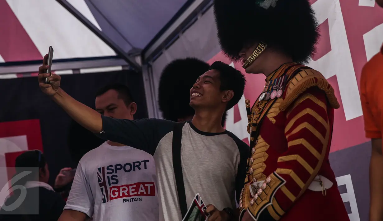 Warga berselfie bersama seorang pasukan Scotts Guard alias penjaga Istana Inggris, usai beraksi di sela kegiatan Car Free Day (CFD) di kawasan Bundaran HI, Jakarta, Minggu (5/6). (Liputan6.com/Faizal Fanani)