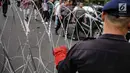 Personel Brimob memasang kawat berduri di sekitar area gedung KPU, Jakarta, Jumat (1/3). Kawat berduri itu untuk mengantisipasi massa Forum Umat Islam (FUI) dan Gerakan Jaga Indonesia yang akan menggelar aksi di depan KPU. (Liputan6.com/Faizal Fanani)