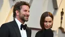 Aktor Bradley Cooper dan model asal Rusia, Irina Shayk  menghadiri perhelatan Oscar 2019 di Dolby Theatre, Los Angeles, Minggu (24/2). Di tengah isu kedekatannya dengan Lady Gaga, Cooper justru tampil mesra dengan Irina Shayk. (Jordan Strauss/Invision/AP)