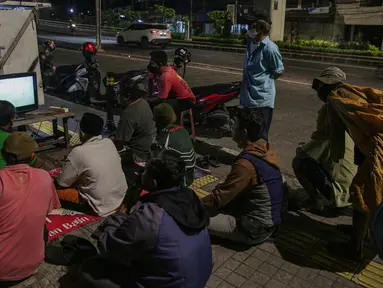 Sejumlah warga menyaksikan pertandingan laga final leg pertama Piala AFF 2020 antara Indonesia melawan Thailand melalui televisi di sejumlah tempat di kawasa Jakarta, Rabu (29/12/2021). Timnas Indonesia harus kalah dengan skor 0-4 atas Thailand. (Liputan6.com/Faizal Fanani)