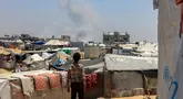 Seorang anak Palestina melihat kepulan asap mengepul dari kejauhan selama pemboman Israel di Rafah, Jalur Gaza Selatan pada 11 Juni 2025. (Foto oleh AFP)
