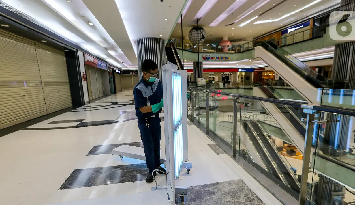 Petugas melakukan penyemprotan disinfektant dengan sinar UV di area kaca Lippo Mall Puri, Jakarta, Rabu (3/6/2020). Lippo Malls Indonesia (LMI) menyiapkan prosedur dengan menerapkan protokol kesehatan menuju new normal di seluruh mal di 34 kota besar di Indonesia. (Liputan6.com/Fery Pradolo)
