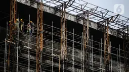 Pekerja memasang 'scaffolding' atau struktur besi untuk melakukan perbaikan Gedung Kejaksaan Agung, Jakarta, yang hangus terbakar, Rabu (7/10/2020).  DPR RI menyepakati penambahan anggaran Kejagung sebesar Rp 350 miliar untuk merenovasi gedung utama yang terbakar hebat. (Liputan6.com/Faizal Fanani)
