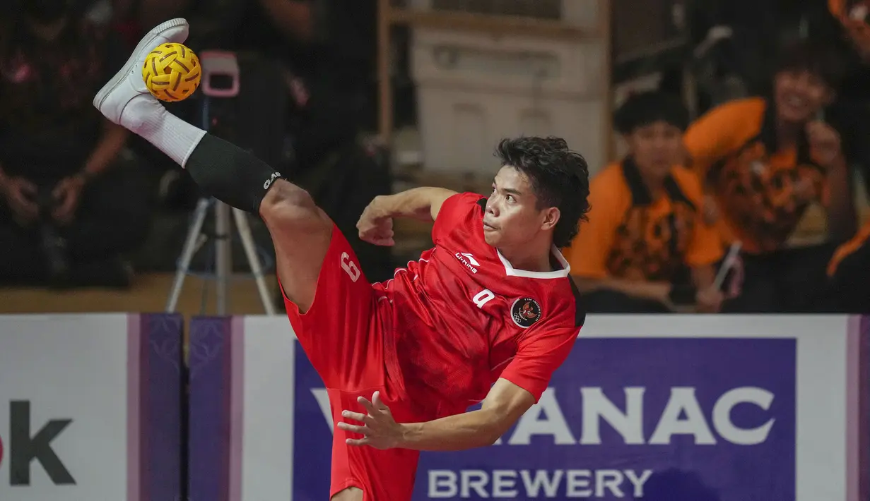 Pemain Tim Sepak Takraw Indonesia, Rusdi menendang bola ke arah Tim Sepak Takraw Malaysia pada laga final nomor ganda putra perorangan sepak takraw SEA Games 2023 di Olympic Stadium, Phnom Penh, Kamboja, Senin (15/05/2023). Indonesia berhasil menang dengan skor skor 14-21, 21-16, dan 21-13. (AP Photo/Tatan Syuflana)