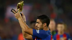 Striker Barcelona, Luis Suarez, menunjukan Sepatu Emas jelang laga La Liga melawan Granada di Stadion Nou Camp, Spanyol, Sabtu (29/10/2016). Suarez meraih gelar ini usai mencetak 40 gol pada musim lalu. (Reuters/Albert Gea)