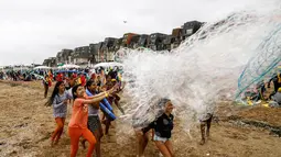 Anak-anak bermain dengan gelembung di pantai Cabourg, barat laut Prancis (18/8/2021). Seratus bus meninggalkan wilayah Paris dari delapan departemen Ile-de-France dengan 5.000 anak muda dari Ile-de-France dalam situasi genting yang belum sempat berangkat musim panas ini. (AFP/Sameer Al-Doumy)