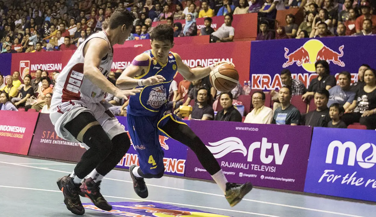 Pebasket Satria Muda Pertamina, Vamiga Michel, berusaha melewati penjagaan pebasket M88 Aspac, Fandi Ramadhani, pada laga IBL Musim 2016 di Hall A Senayan, Jakarta, Sabtu (9/1/2016). (Bola.com/Vitalis Yogi Trisna)