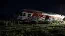 Sebuah kereta api keluar rel dan menghantam satu rumah di dekatnya di Desa Adendro, Yunani, Minggu (14/5). Kecelakaan tersebut menewaskan empat orang dan melukai lima lainnya. (AP/Giannis Papanikos)