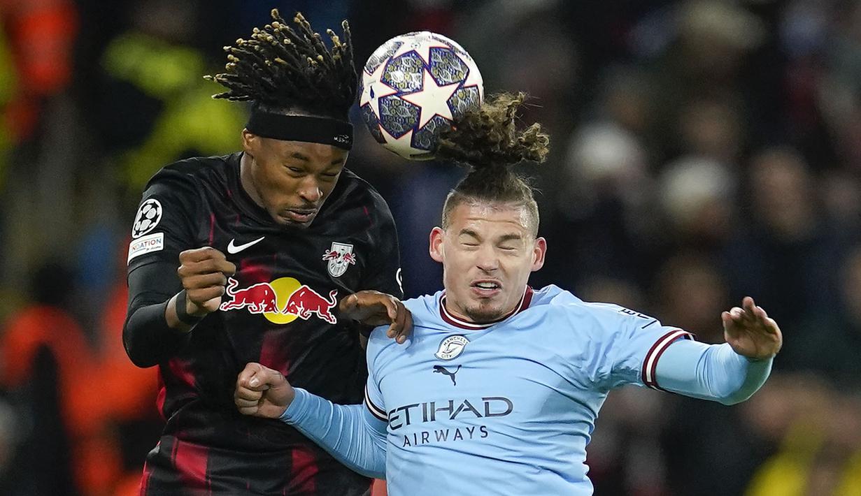 <p>Pemain Manchester City, Kalvin Phillips (kanan) berebut bola dengan pemain RB Leipzig, Mohamed Simakan pada laga leg kedua 16 Besar Liga Champions 2022/2023 di Etihad Stadium, Manchester, Rabu (15/03/2023). The Cityzens berhasil melaju ke babak perempat final setelah berhasil menang dengan skor 7-0. (AP Photo/Dave Thompson)</p>