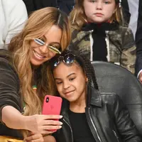 Penyanyi Beyonce dan putrinya Blue Ivy Carter berselfie saat menonton pertandingan NBA All-Star Game 2018 di Staples Center di Los Angeles, California, AS (18/2). (Allen Berezovsky/Getty Images/AFP)