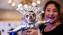 Pemilik berpose dengan anjingnya yang didandani untuk sebuah pertunjukan pada New York Pet Fashion Show ke-17 di New York City, Kamis (6/2/2020). Acara ini menampilkan pertunjukan anjing yang berjalan di catwalk dengan kostum yang unik. (Photo by Johannes EISELE / AFP)