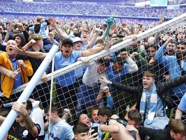 Suporter Manchester City langsung turun ke lapangan usai Manchester City berhasil menaklukkan Aston Villa pada laga pekan terakhir Liga Inggris. (Martin Rickett/PA via AP)