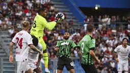 Kiper Milan Mike Maignan beraksi menangkap bola saat bertanding melawan Sassuolo pada pertandingan lanjutan Liga Serie A Italia di stadion Mapei - Citta del Tricolore di Reggio Emilia (30/8/2022). AC Milan bermain imbang atas Sassuolo dengan skor 0-0. (Massimo Paolone / LaPresse via AP)