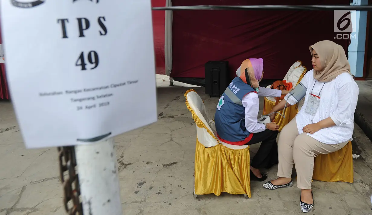 Petugas medis Puskesmas memeriksa tekanan darah petugas Kelompok Penyelenggara Pemungutan Suara (KPPS) yang bertugas saat pemungutan suara ulang di TPS 49 Rengas, Ciputat Timur, Tangsel, Rabu (24/4). Pemeriksaan untuk antisipasi menurunnya kesehatan fisik akibat kelelahan. (merdeka.com/Arie Basuki)