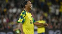 Mantan pemain sepak bola Brasil, Ronaldinho, memberi isyarat selama pertandingan ekshibisi Joga Bonito Tour antara Ronaldinho XI dan Cahill XI di Sydney pada 1 November 2024. (SAEED KHAN/AFP)