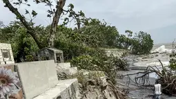 Seorang pria berjalan di sepanjang tembok yang rusak akibat topan Batsirai di Mahanoro pada 6 Februari 2022. Topan Batsirai melemah tetapi banjir masih diperkirakan terjadi karena hujan lebat setelah melanda Madagaskar timur dengan angin kencang. (Laure Verneau / AFP)