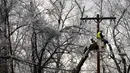 Seorang pekerja memperbaiki kabel listrik saat badai musim dingin di West Orange, New Jersey (18/12/2019). Badai musim dingin membawa malapetaka ke New Jersey ketika es menyebabkan pemadaman listrik dan menumbangkan pohon di seluruh wilayah tersebut. (Rick Loomis/Getty Images/AFP)