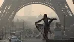 Seorang model cantik berpose di depan menara Eiffel saat matahari terbit dalam sesi pemotretan, Paris (11/3/2016). (AFP/Ludovic MARIN)