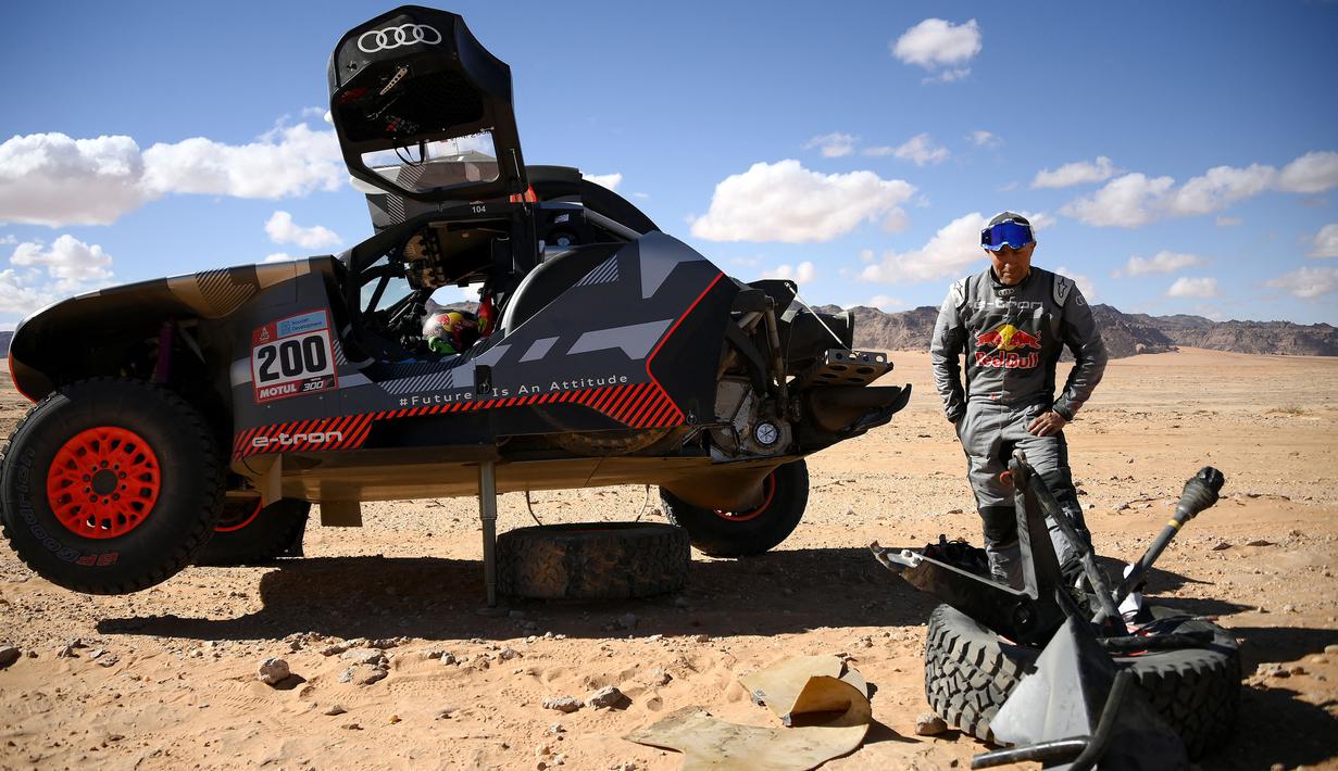 Reaksi kecewa pembalap kendaraan listrik Audi dari Prancis, Stephane Peterhansel di samping mobilnya setelah kecelakaan selama Stage 1B Reli Dakar 2022 di sekitar kota Hail Saudi, pada 2 Januari 2022. (AFP/Franck Fife)
